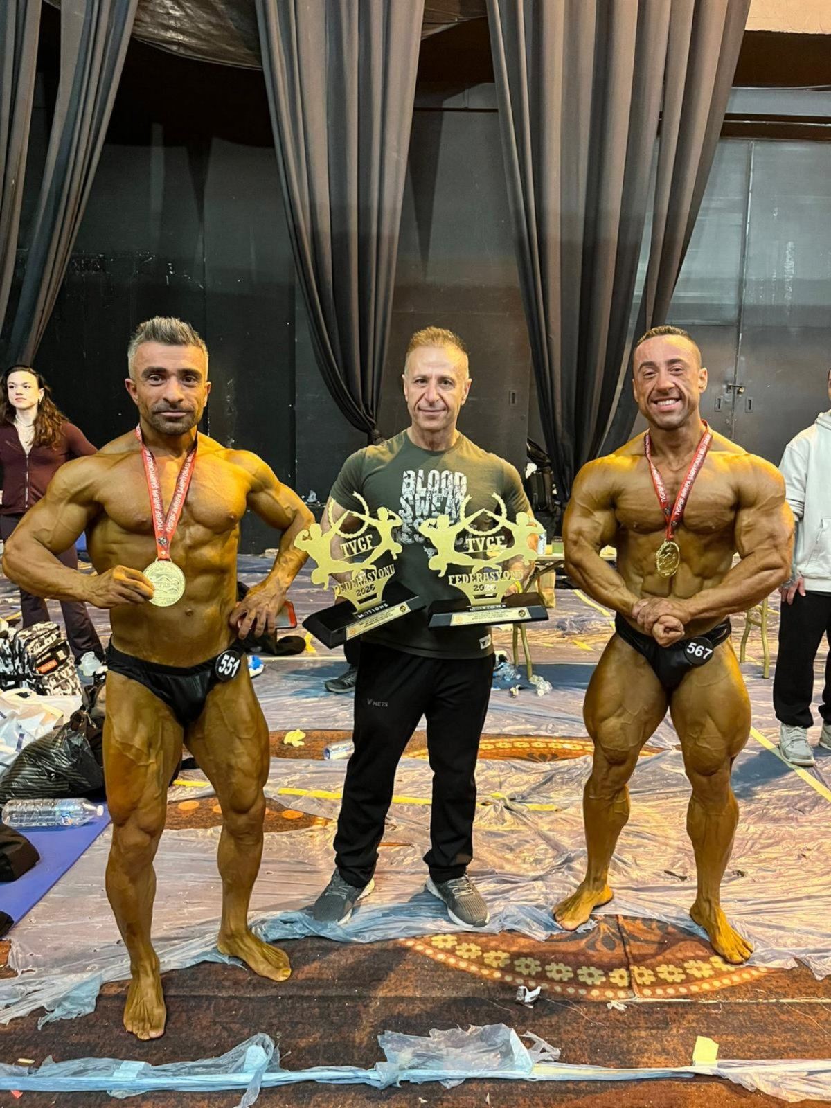 İsmail Yalçın kürsüde diğer sporcularla, kupalar
